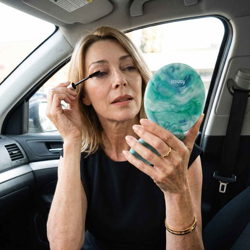Model fixing her mascara in the car with her Taylor Lighted Compact in Sea Serenity